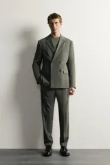 Blazer cruzada de traje color verde militar, de corte regular fit, con solapas de muesca, cierre frontal de doble botonadura, bolsillos con solapa en la cadera y bolsillo de vivo en el pecho.