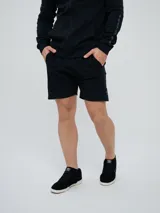 Bermuda deportiva Umbro modelo Terrace, color negro, con bolsillos laterales y detalles sutiles en el lateral.