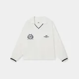 Buzo tipo polo de manga larga en color marfil, confeccionado en suave algodón piqué con detalles en azul marino en el cuello y los puños. Presenta escudos bordados en el pecho y puños elásticos.
