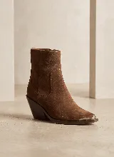 Bota corta de cuero vacuno color marrón topo, con diseño de estilo western, taco cuadrado de 7 cm y puntera metálica decorativa. Cuenta con cierre lateral interno para facilitar el calce.