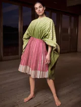 Poncho con capucha a rayas horizontales verdes y blancas, con falda a rayas verticales rosas y marrones.