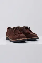 Zapato abotinado de gamuza color caramelo, con cordones, detalle de flecos en el empeine y suela de goma negra con costuras a la vista.