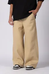 Jean baggy color beige, de fit amplio y relajado, con diseño de perneras anchas y costuras decorativas laterales.