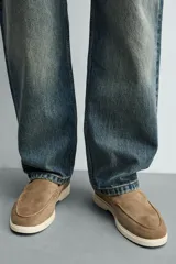 Mocasín casual de hombre, color azul marino, con parte superior de serraje (gamuza) y suela de goma a contraste color beige. Presenta un detalle de bordón cosido en la pala.