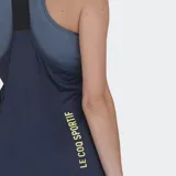 Musculosa deportiva Le Coq Sportif color azul marino, con logo del gallo en amarillo. Presenta un diseño de doble capa, con un top deportivo de tirantes finos con estampado sutil debajo de la musculosa principal.