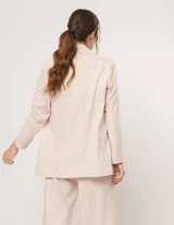 Blazer oversized color beige de corte recto, confeccionado en tela con lino.