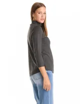 Buzo de tejido fino en color gris oscuro, con cuello alto acanalado y mangas tres cuartos. Presenta un diseño con líneas acanaladas en diagonal desde el cuello hacia las sisas y pequeños tajos laterales en el ruedo.