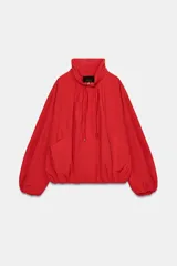 Cazadora bomber roja de la colección Zara Woman, con cuello subido ajustable con cordones, manga larga con puño elástico y stopper, bolsillos delanteros y cierre frontal con cremallera metálica y botones a presión ocultos.