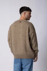 Sweater de punto grueso en color verde oliva, con diseño oversized, cuello redondo y mangas largas con puños acanalados.