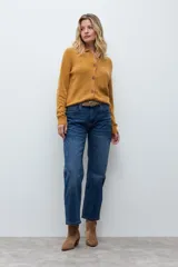 Cardigan de punto color ocre, con diseño calado de pequeños motivos florales, cuello polo y cierre frontal con botones.
