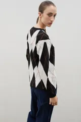 Buzo de punto con diseño de rombos en tonos azul y marrón, con cuello redondo y mangas largas.