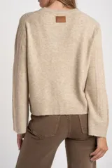 Sweater de punto con textura acanalada vertical, color beige melange, de cuello redondo y manga larga con puños rectos.