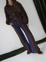 Pantalón de paño combinado con tira de cuero color marrón.