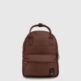 Mochila Bubba modelo Montreal color marrón, con diseño acolchado, compartimento principal con cierre, bolsillo frontal con cierre y asa superior. Incluye etiqueta de marca en la parte inferior.