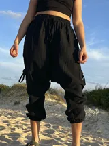 Pantalón babucha negro de muselina con cintura elástica y cordones ajustables en los tobillos.