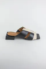 Sandalias descalzas de cuero combinadas en negro y beige, con taco cuadrado bajo y puntera cuadrada.