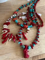Collar hecho a mano con cuentas de coral rojo y turquesas, con cadena plateada ajustable.