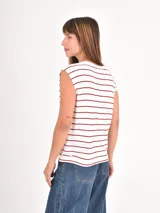 Remera sin mangas de corte holgado, con cuello redondo y diseño de rayas horizontales finas en color negro sobre fondo blanco.