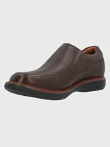 Zapato tipo mocasín Hush Puppies modelo Oregon, confeccionado en cuero vacuno con textura granulada. Presenta un diseño sin cordones con elásticos laterales para un ajuste cómodo, costuras reforzadas y suela de goma EVA de alto rendimiento.