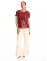 Blusa de manga corta con cuello redondo, confeccionada en tejido cubierto de lentejuelas color verde esmeralda. Cuenta con forro interno a tono y un corte recto.