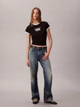 Remera Calvin Klein ajustada de manga corta, color negro con ribetes blancos en el cuello redondo y los puños. Presenta un estampado gráfico en el pecho con el texto y logo de la marca y el año 1968.