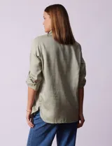 Camisa verde claro de tencel, marca Hester & Orchand. Cuello con solapa, escote en V y abertura central con botones. Delantera con bolsillos. Largo de manga regulable con presilla y botón.