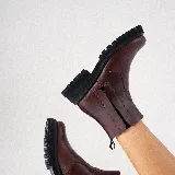 Bota corta estilo chelsea de cuero vacuno negro con acabado desgastado en tono marrón en la puntera y laterales. Presenta elástico lateral, cierre interno y suela de goma tipo track con plataforma.