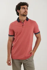 Remera tipo polo de manga corta, color azul marino jaspeado, con cuello y ribetes en las mangas de color azul oscuro y blanco.