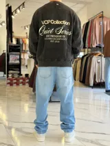Buzo oversize de cuello redondo en color marrón con efecto gastado, con gran estampado en la espalda de estrellas y el texto VCP CNPT.
