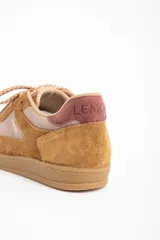 Zapatilla deportiva de caña baja, con paneles combinados en gamuza color camel y material liso color rosado pálido. El cuello y el talón son de color vino o rosado oscuro. Cordones trenzados en tonos beige y naranja. Suela de goma color camel.