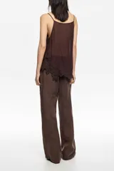 Pantalón de corte recto y tiro alto, confeccionado en una mezcla de lyocell y viscosa, con acabado mate y diseño de pierna ancha.