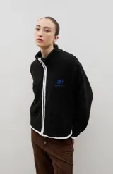 Campera de sherpa color beige con cuello alto, cierre frontal completo y bordado a contra tono en el pecho.