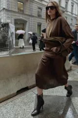 Vestido midi de manga larga, con parte superior tipo buzo de tejido liso color marrón oscuro y falda larga plisada de tejido satinado marrón oscuro.