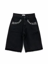 Bermuda de denim negro con corte recto y largo hasta la rodilla. Presenta detalles de pedrería brillante en los bolsillos delanteros y ruedo deshilachado.