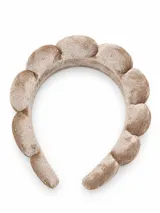 Vincha acolchada de terciopelo color beige, con diseño abullonado y apliques de pequeños cristales brillantes.