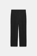 Pantalón de tiro medio con cintura con trabillas, detalle de raya planchada y bajo con aberturas laterales. Cierre frontal con cremallera, botón y ganchos metálicos.