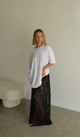 Pollera larga de encaje negro, corte recto y tiro alto.