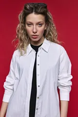 Camisa de manga larga color blanco, con cuello clásico y cierre frontal de botones de nácar. Presenta un corte cómodo y versátil.