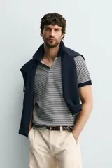 Chomba de punto con diseño de micro rayas horizontales en color azul marino y blanco, con cuello solapa y puños en contraste.