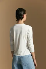 Remera de manga larga en color negro, con cuello redondo y costura vertical central en el frente. Presenta un diseño minimalista de calce ajustado y líneas limpias.
