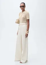 Pantalón de jean estilo wide leg color crudo, de tiro alto con cierre frontal de cremallera y botón, bolsillos laterales y bolsillos de parche traseros.