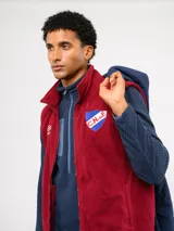 Parka de abrigo Umbro del Club Nacional de Football, con diseño de bloques de color en azul, rojo y blanco. Cuenta con capucha, cierre frontal, bolsillos frontales y el escudo del club bordado en el pecho.