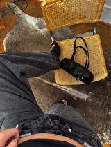Jean de corte baggy con cintura cruzada asimétrica y diseño de tiro bajo, confeccionado en denim de color negro lavado.