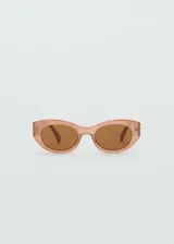 Lentes de sol con montura de pasta ovalada y translúcida en tono rosado, con cristales marrones y protección UV total.
