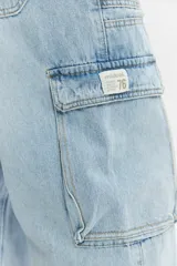 Jean cargo de algodón con calce suelto, color negro lavado con efecto desgastado, con múltiples bolsillos utilitarios en los laterales.