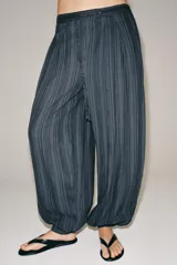Pantalón bombacho Zara Woman Collection, confeccionado en mezcla de algodón, con tiro medio, cintura elástica y cordón ajustable. Presenta diseño a rayas sutiles, bajo abullonado con puño y cierre frontal con botón.