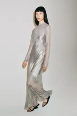Vestido largo de satén y encaje color gris, con cuello redondo, manga larga y cierre en la espalda con abertura y botón.