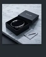 Pulsera masculina con banda de caucho negro y eslabones centrales de acero inoxidable con diseño geométrico grabado.
