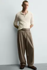 Pantalón de corte balloon fit en color gris, confeccionado en tejido con viscosa. Presenta pliegues frontales, cintura con cinturón integrado a contraste, bolsillos laterales y bolsillos traseros de vivo.