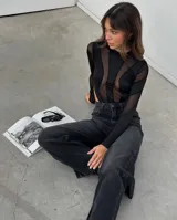 Body negro de mangas largas confeccionado en tejido de punto con transparencias.